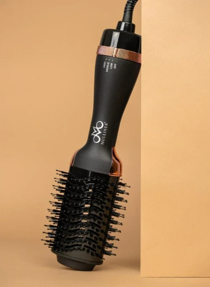 Black hair styling tool with rose gold accents on a beige background